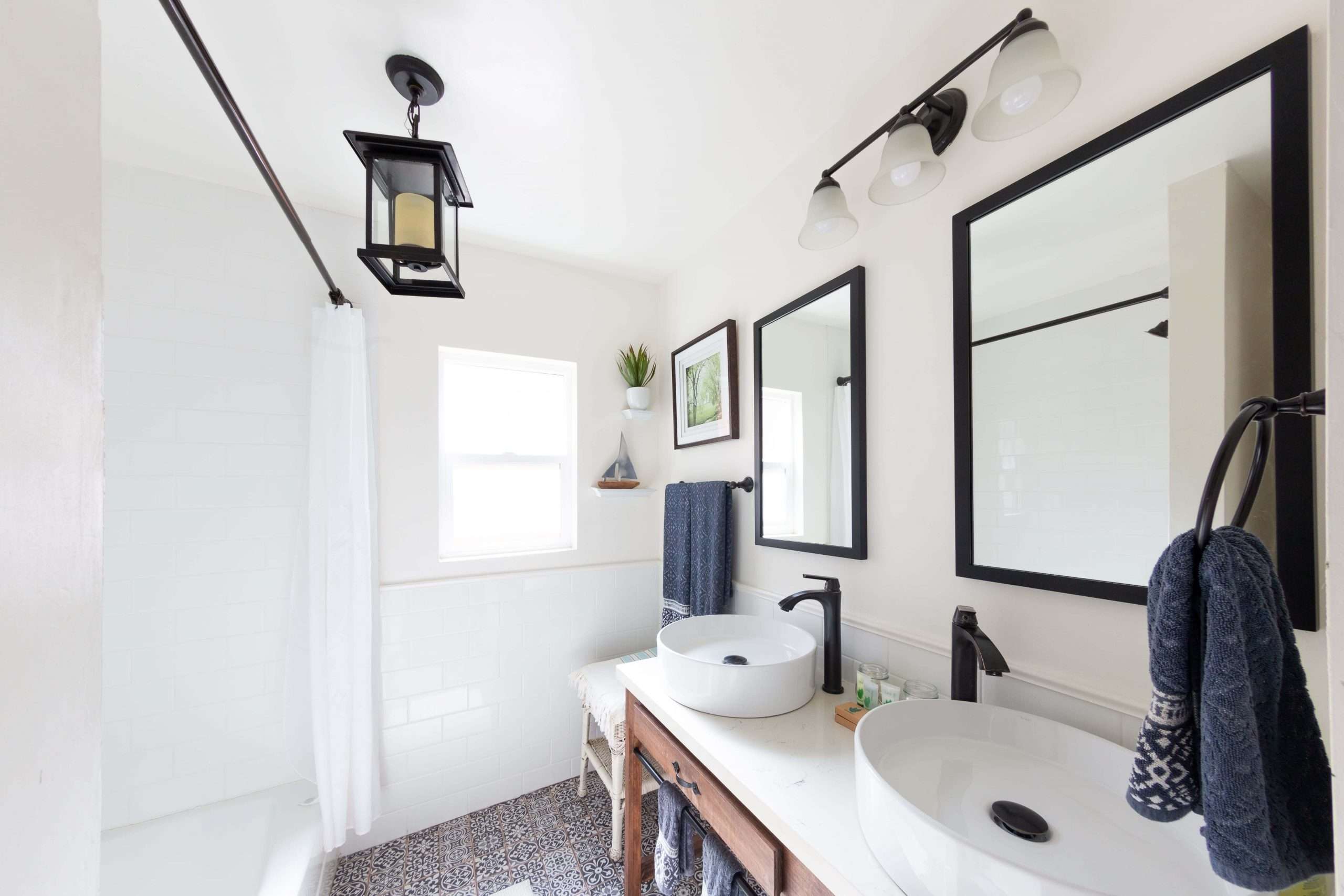 Bathroom with twin vessel sinks on the wooden, writer's-desk-style vanity and a shower over the bath